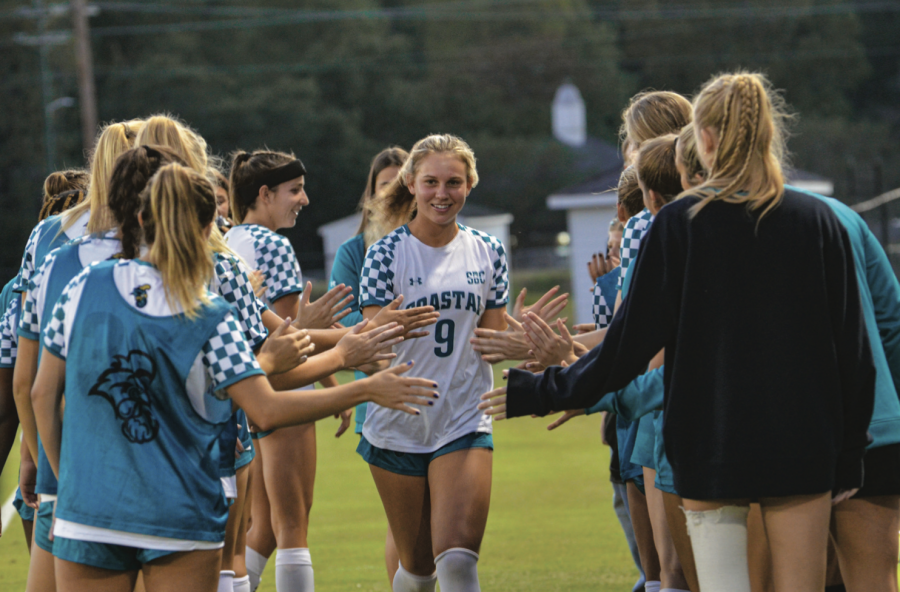 The+team+celebrates+freshman+Maggie+Mace+after+her+assist+in+the+second+half.