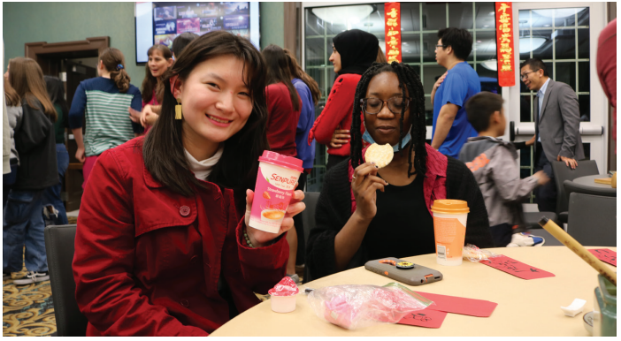 Morgan Freiler (left ) and Dara Olufemi (right) enjoy Senpure and snacks
provided by the Intercultural Language Resource Center and Center for Global
Engagement.