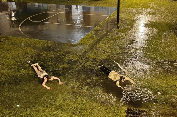 Two University Place residents dive through the flood waters near the Grand Strand building Aug. 30. 