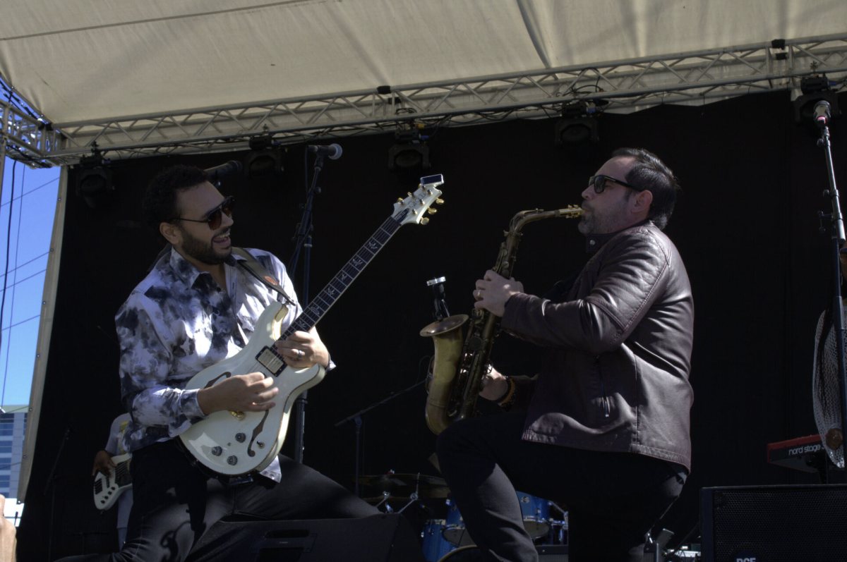 Guitarist Adam Hawley and saxophonist Jason Jackson perform and collaborate on stage.