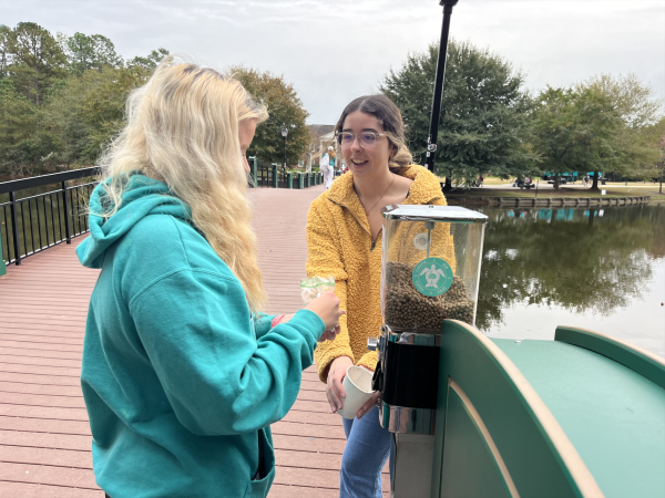 Marine science majors Chloe Alger, sophomore, and Ellie Crane, freshman, use the turtle feeder Nov. 15. 