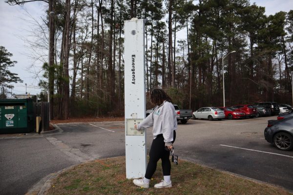 A student uses one of the many call boxes located on campus. Photo illustration by Keller Goldstein.
