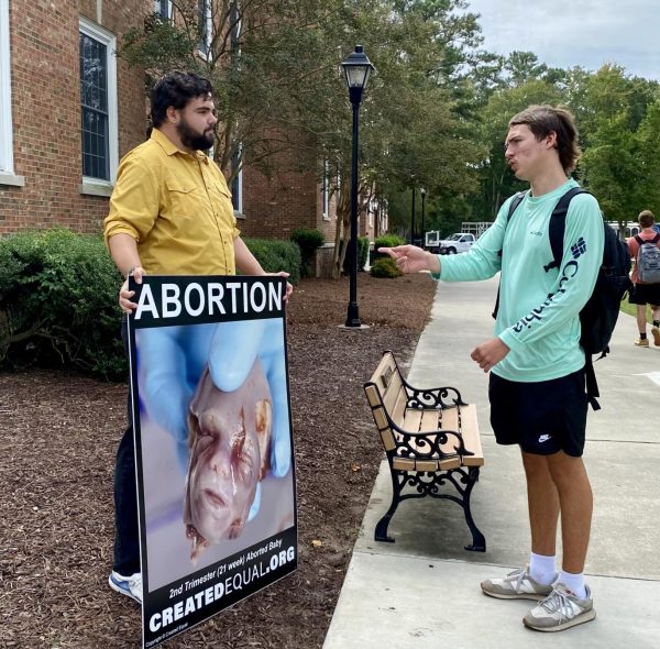 One protestor and counter protestor discussing abortion outside of Kearns Hall, who later shook hands.