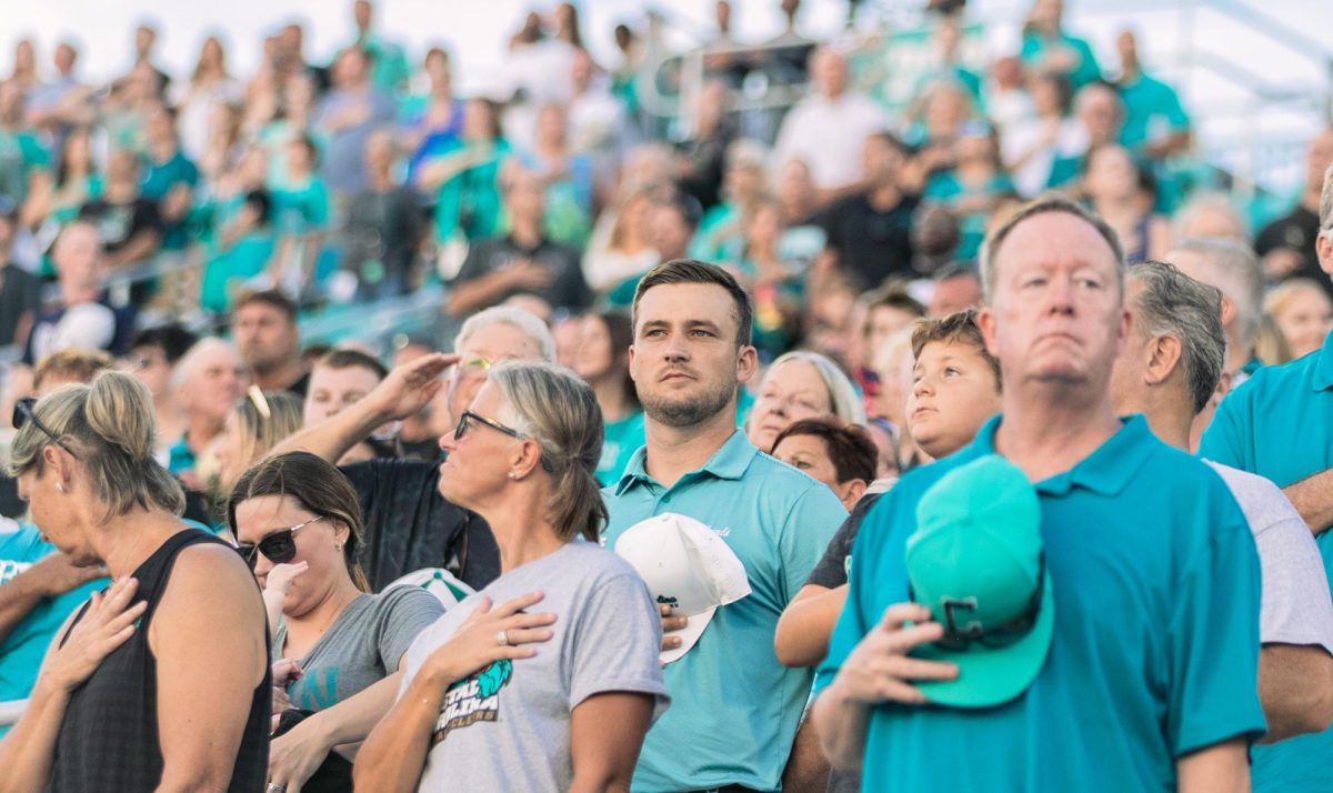 Fans stand for the playing of the national anthem. 
