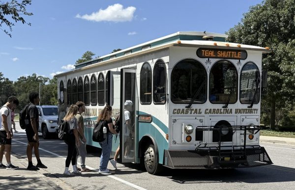 CCU students make their way onto the teal shuttle at the Chanticleer west shuttle station