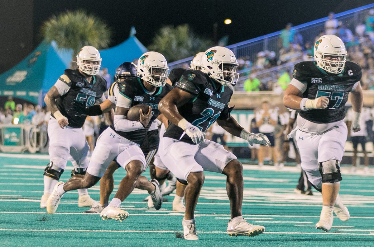 Quarterback MJ Morris holds on to the ball for a run up the middle. 