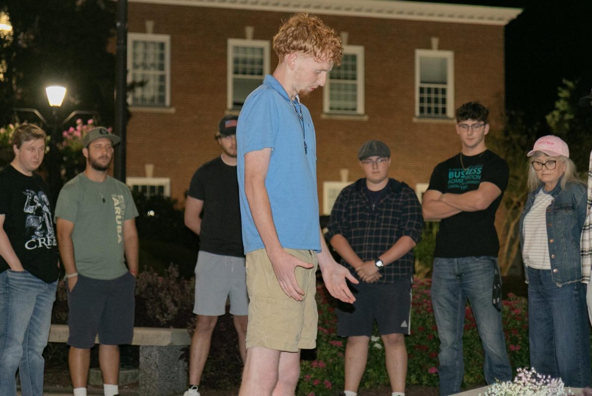 CCU student prays to Charlie Kirk at a vigil hosted on prince lawn. 