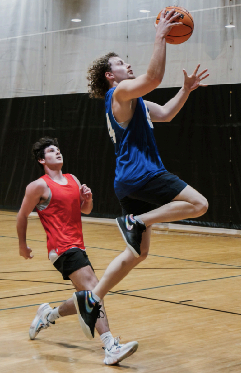 5v5 student competitor drives to the net for a layup.