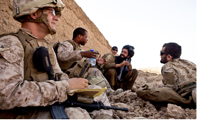 David Brownfield sits, left, with Sgt. Curtis and a local Afghan man speaking. Behind the local man sits a
Georgian interpreter and in front of the local man is an Afghani interpreter. Photo taken during one of
their helicopter assault missions. Photo courtesy of David Brownfeld